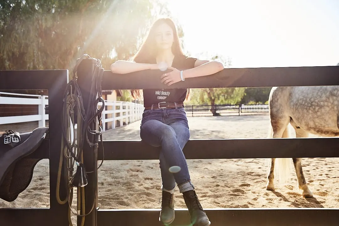 Mackenzie Foy sitting on the pen fence